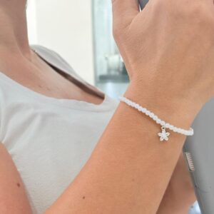 PULSERA CON SIMIL PERLA Y DIJE MARGRITA CON PIEDRAS